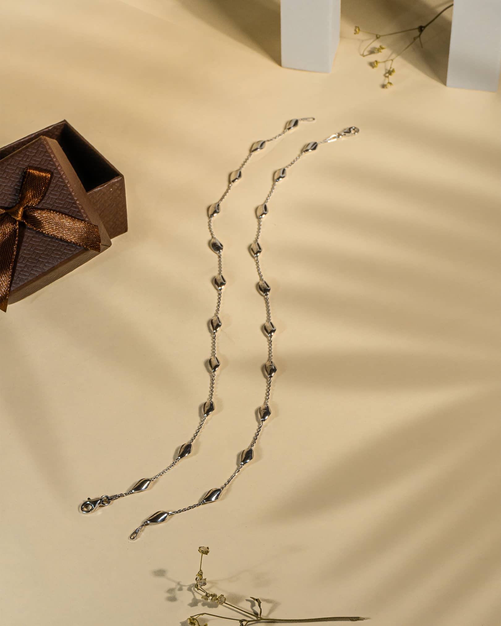 925 sterling silver minimalist anklet with spaced polished oval beads and lobster clasp.