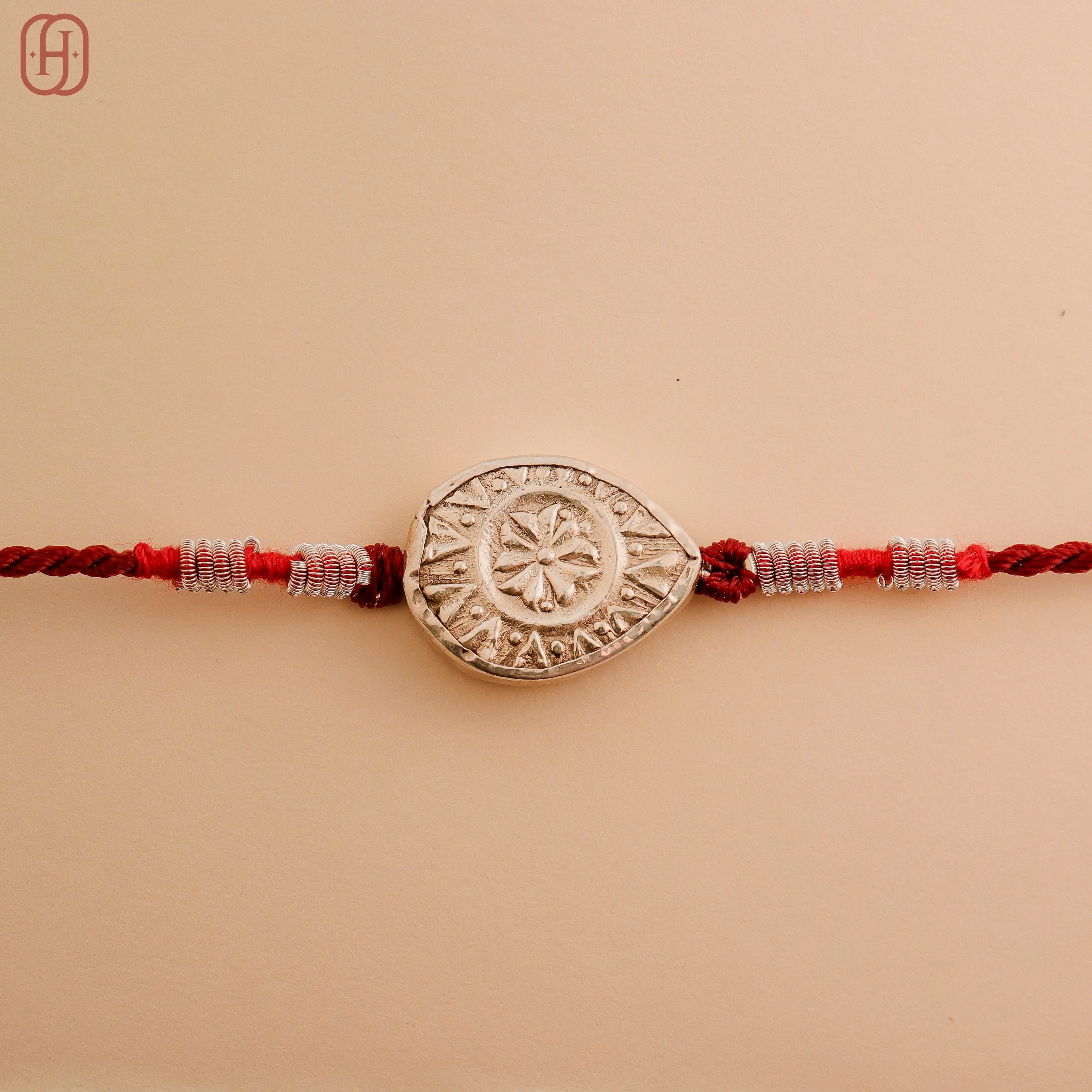 Hardik Jewels Teardrop Rakhi Design with Silver Charm.