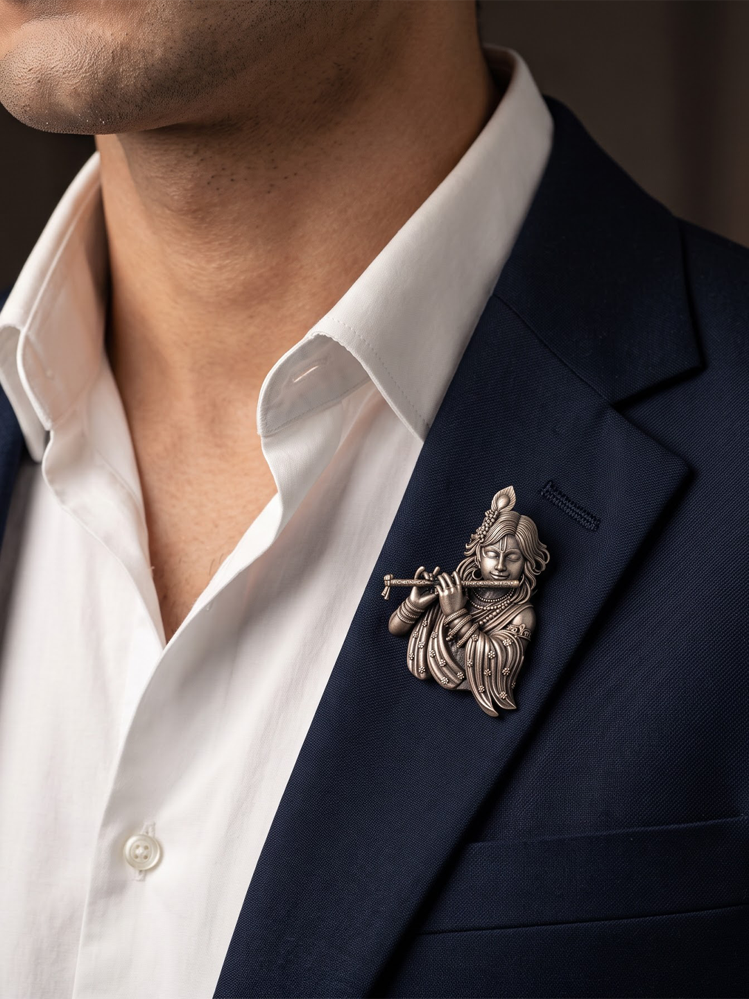 Man wearing silver Krishna flute brooch on a blazer lapel