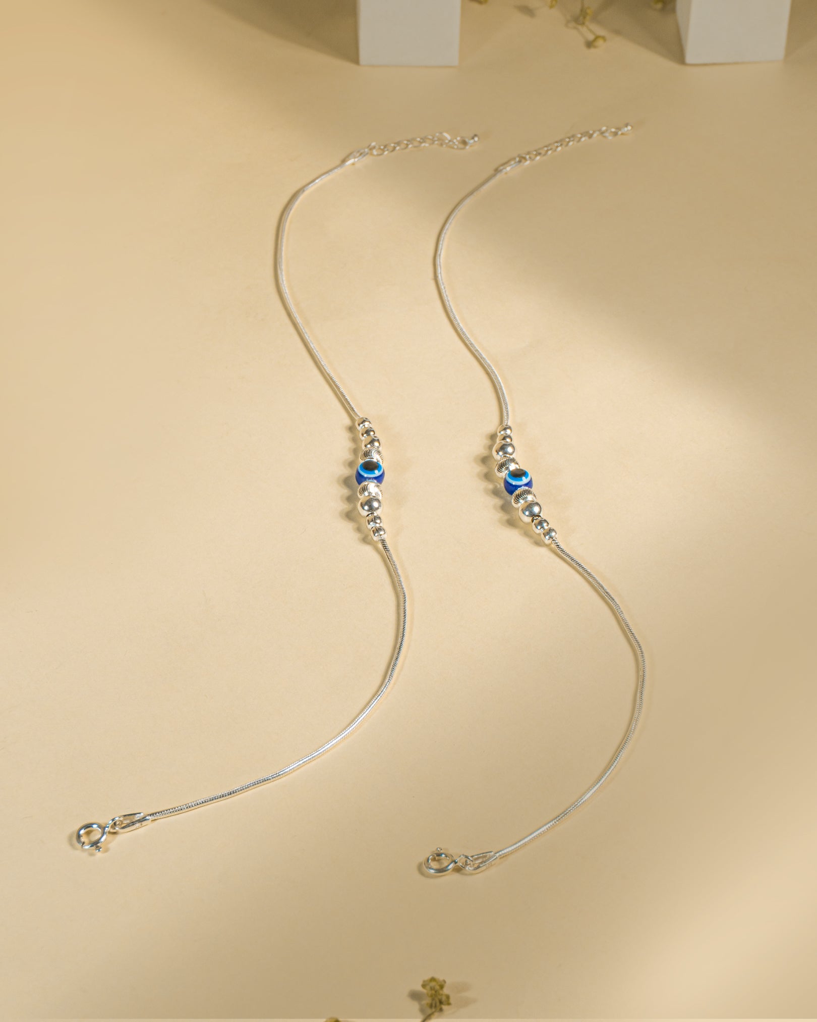 925 Sterling Silver Nazariya Payal featuring a blue evil eye bead on a snake chain, isolated on white background.