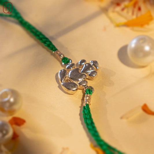 Ganesh Ji face silver rakhi online with green thread and intricate silver Ganesh design by Hardik Jewels