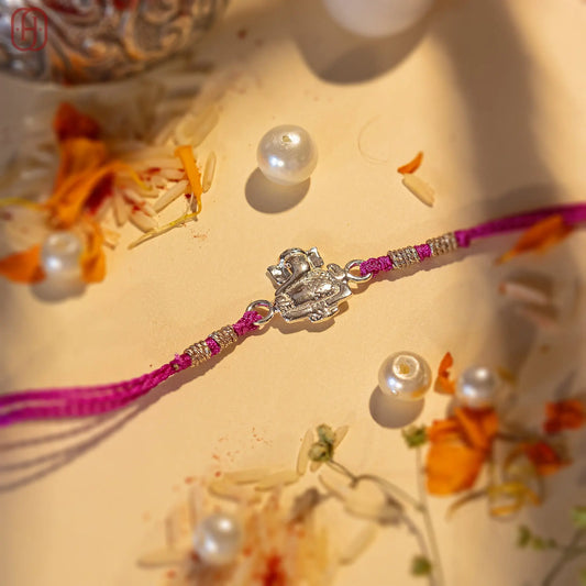 Ganesh Ji face rakhi in silver with purple thread and silver beads by Hardik Jewels