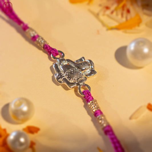 Ganesh Ji face rakhi in silver with purple thread and decorative beads by Hardik Jewels