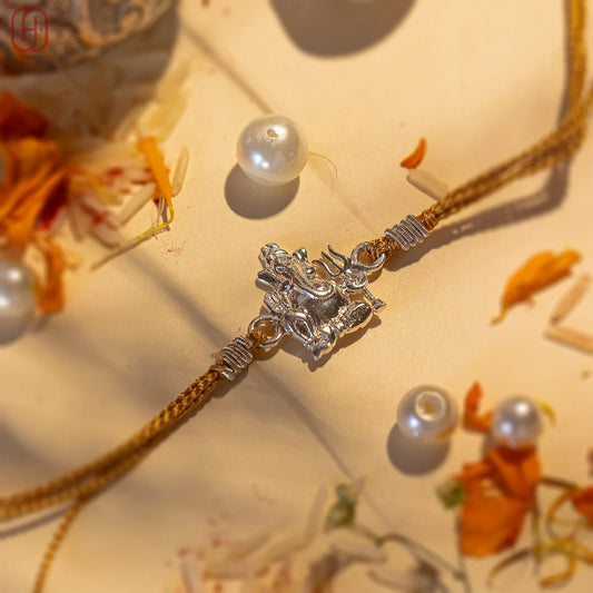 Ganesh silver rakhi with intricate silver Ganesh charm on traditional thread by Hardik Jewels