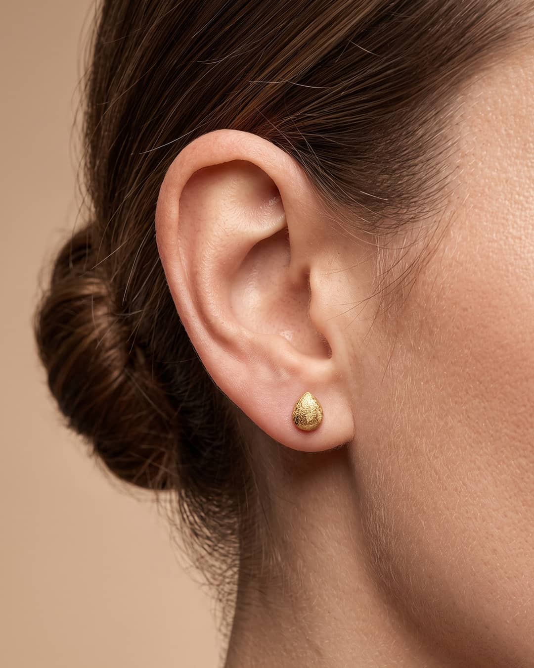 Golden Teardrop Textured Silver Stud Earrings - ear styling view - Hardik Jewels