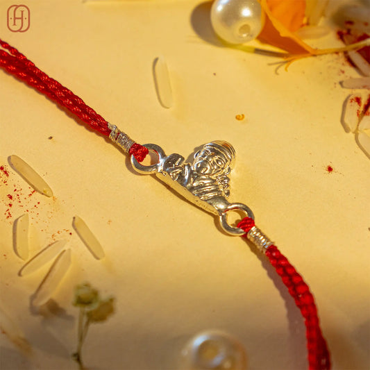 Hardik Jewels 92.5 silver rakhi bracelet with red braided thread and a detailed silver centerpiece