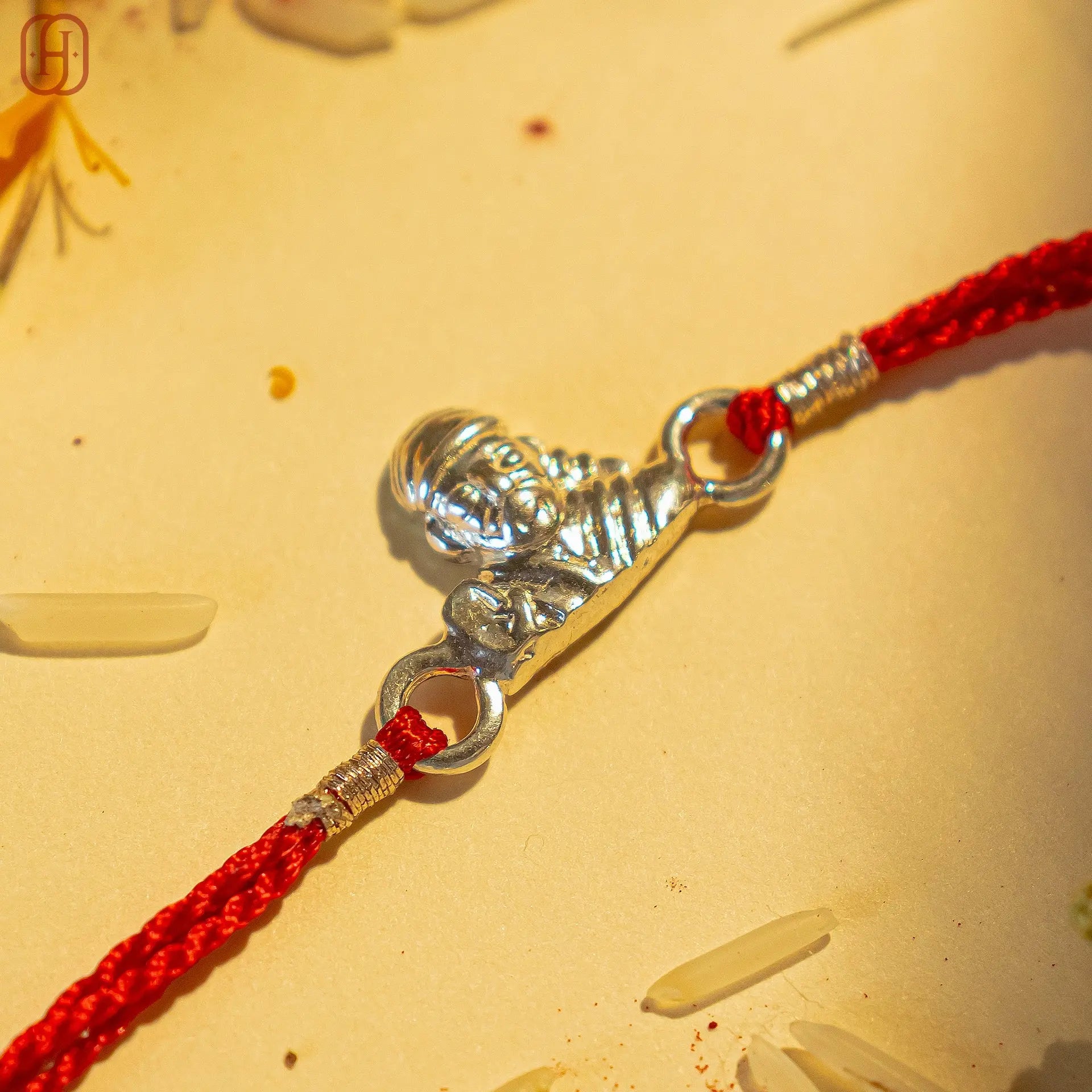 92.5 silver rakhi bracelet with silver Lord Krishna charm on a red braided thread from Hardik Jewels