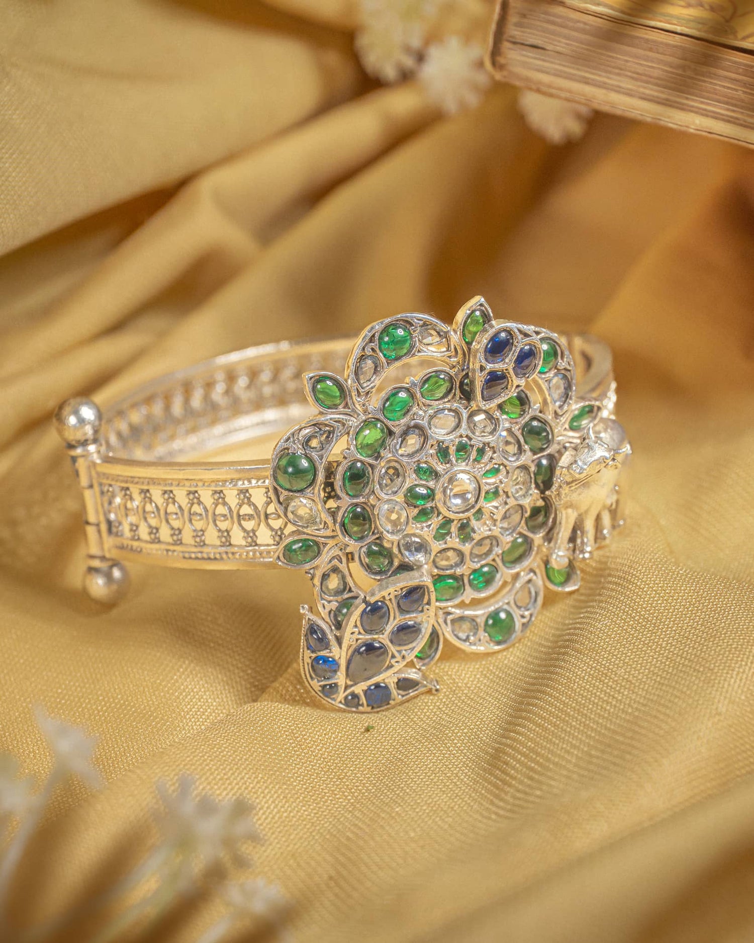 92.5 sterling silver antique jadau bangle featuring large floral motif with green and blue stones.
