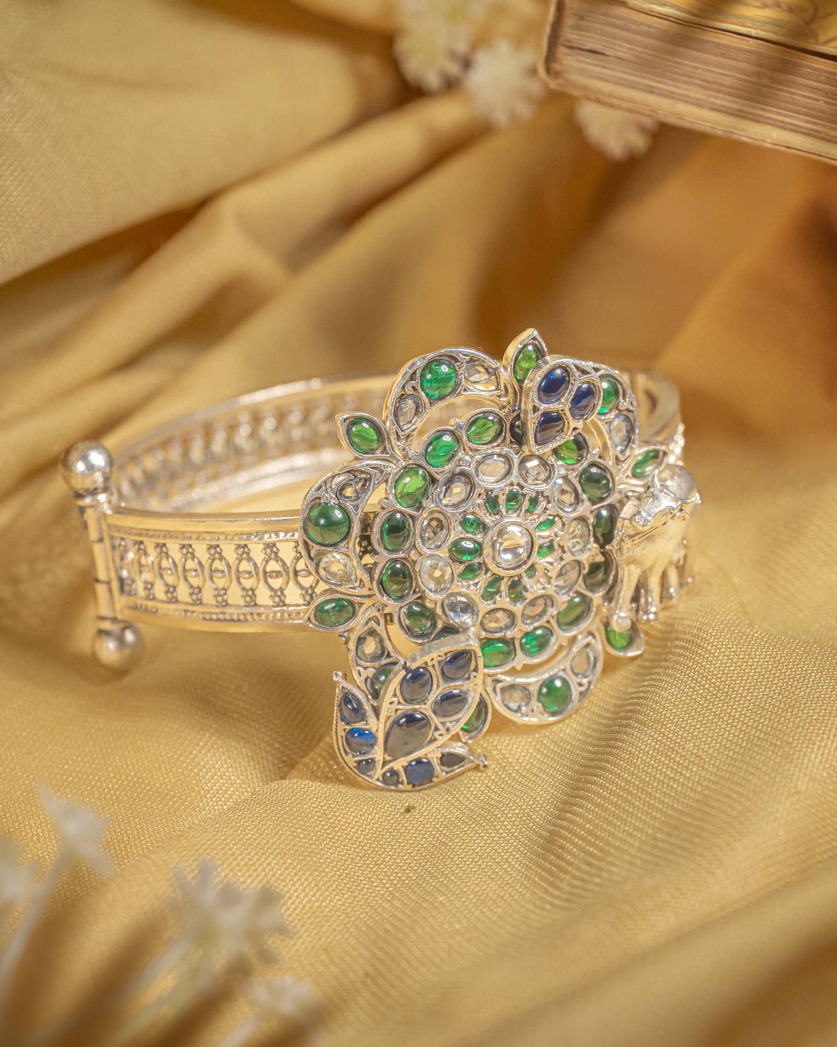 92.5 sterling silver antique jadau bangle featuring large floral motif with green and blue stones.