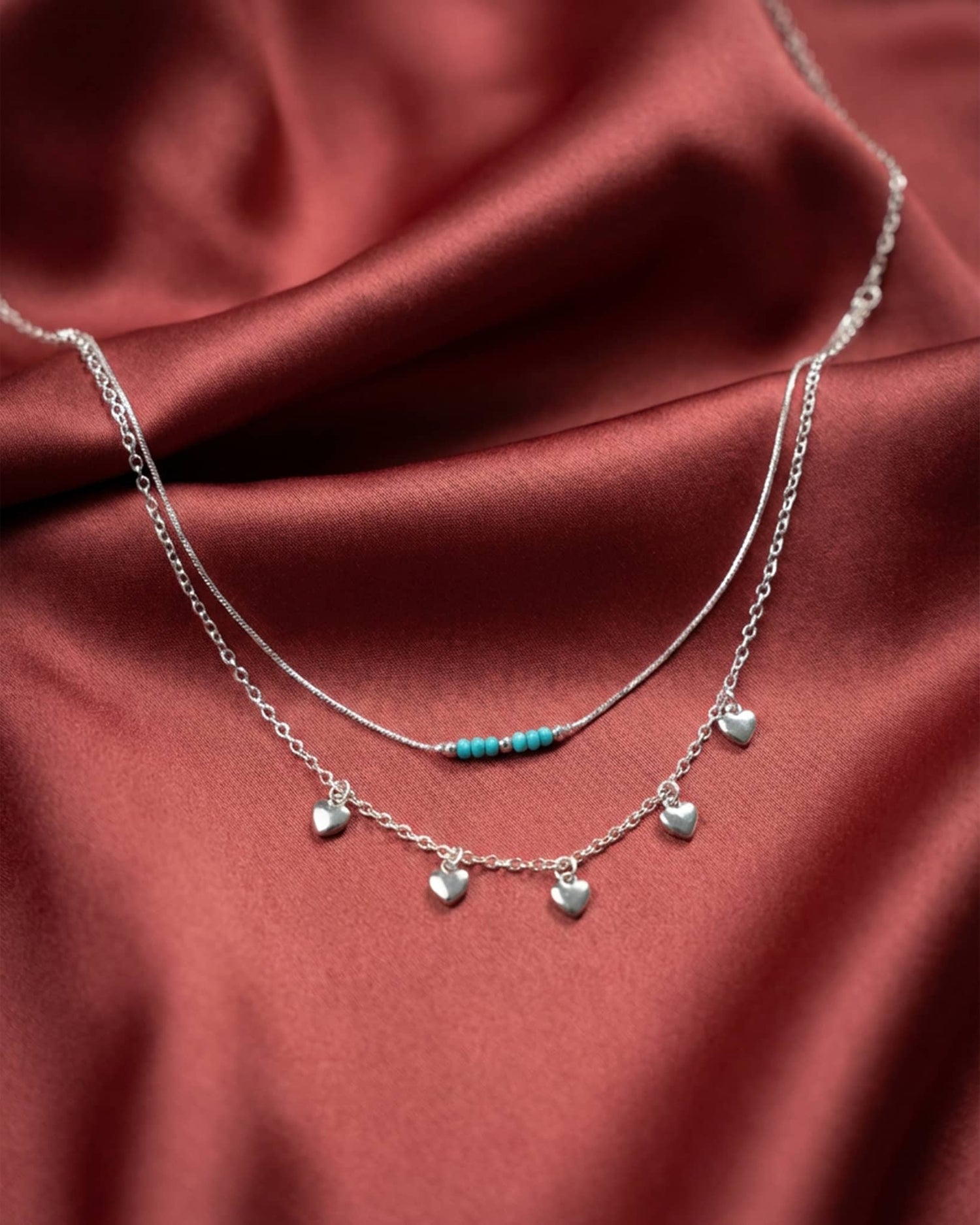 92.5 sterling silver double layer necklace with turquoise beads and dangling heart charms.