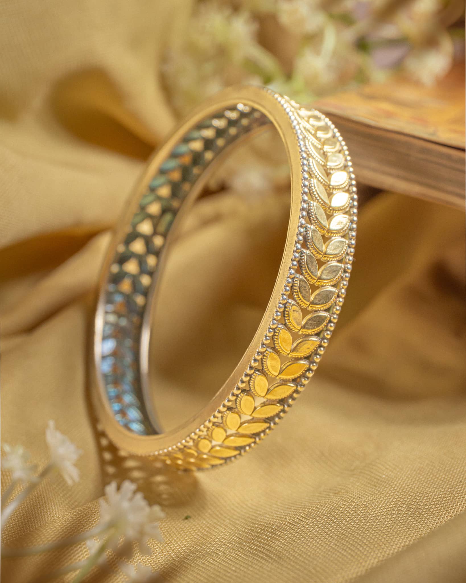 92.5 sterling silver dual tone bangle featuring oxidized finish with gold plated accents and ghungroo bells.
