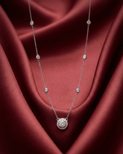 92.5 sterling silver necklace featuring a round solitaire halo pendant and bezel set stones on the chain.