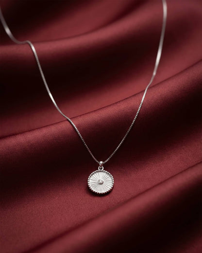 92.5 sterling silver necklace featuring a round white pendant with sunburst texture and cz center.