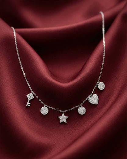 92.5 sterling silver necklace featuring dangling key star heart and disc charms studded with diamonds.