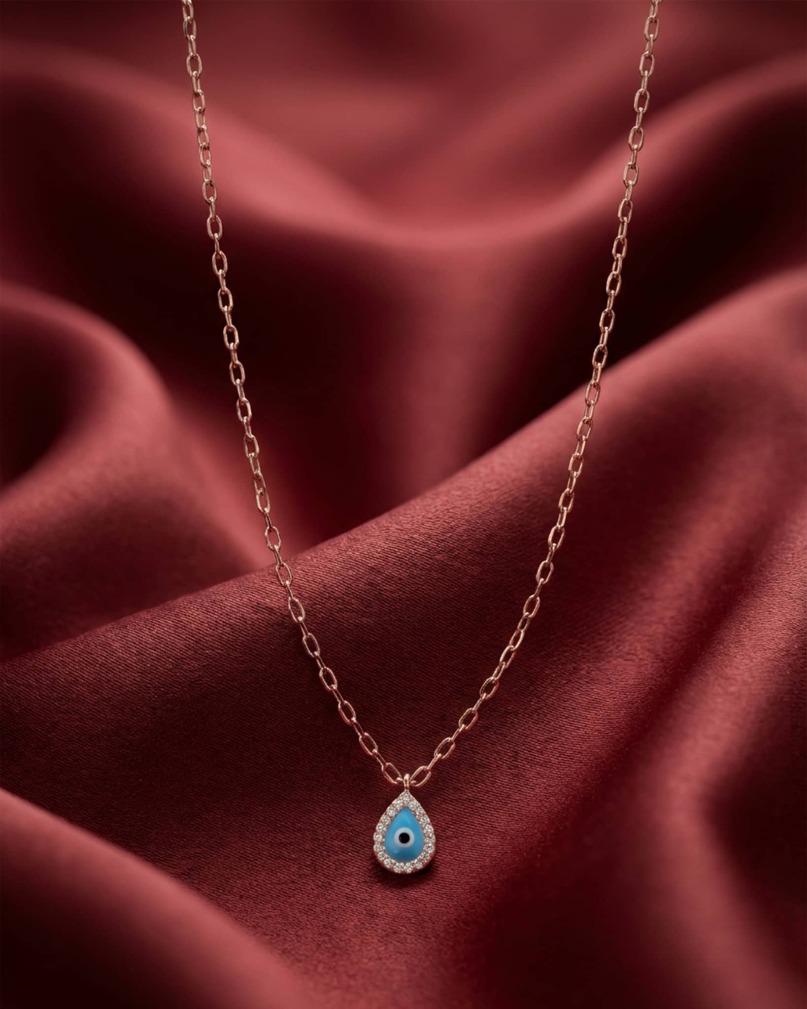 92.5 sterling silver rose gold plated necklace featuring a teardrop evil eye pendant with diamond halo.