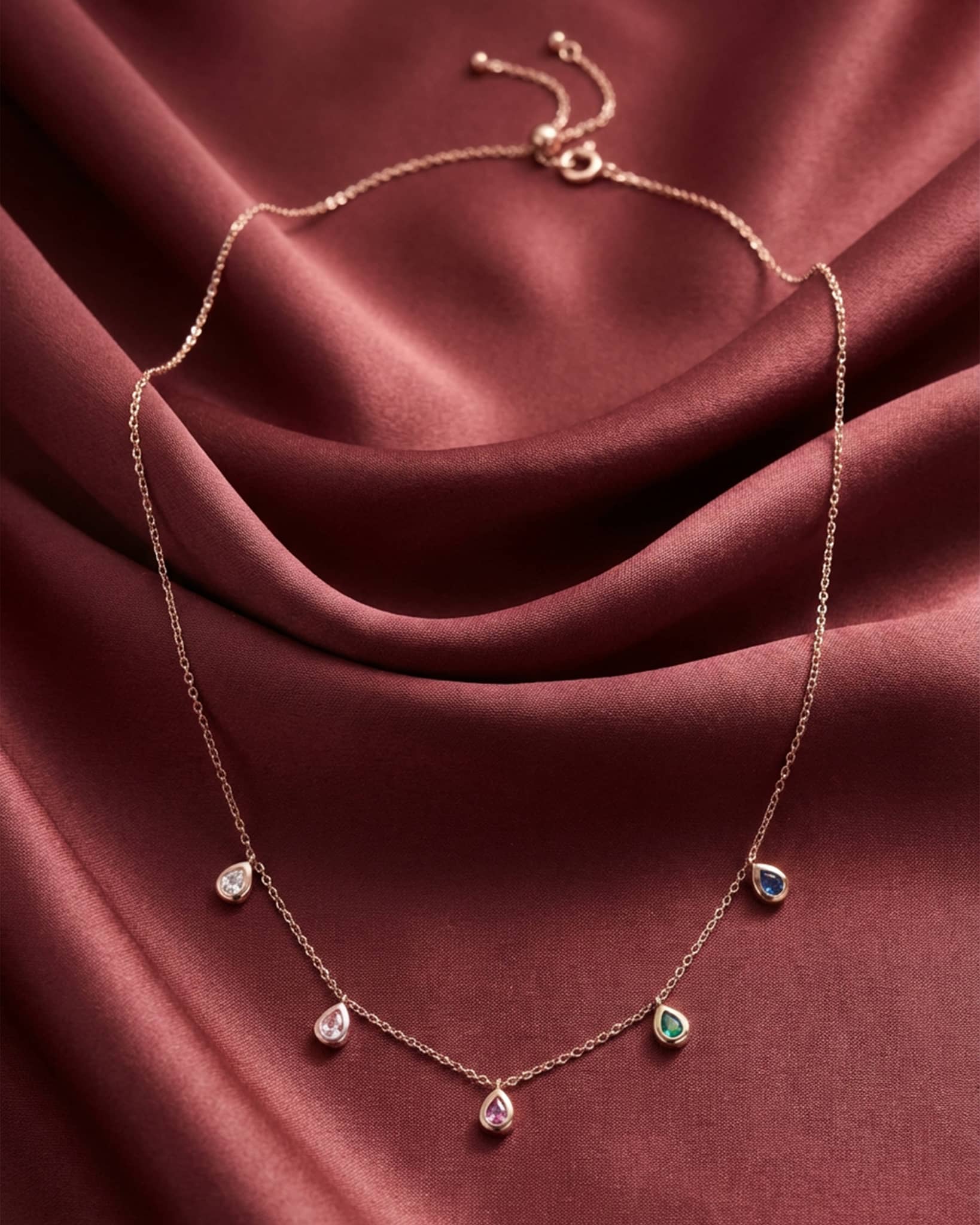 92.5 sterling silver rose gold plated necklace with multi colored teardrop charms and adjustable slider clasp.