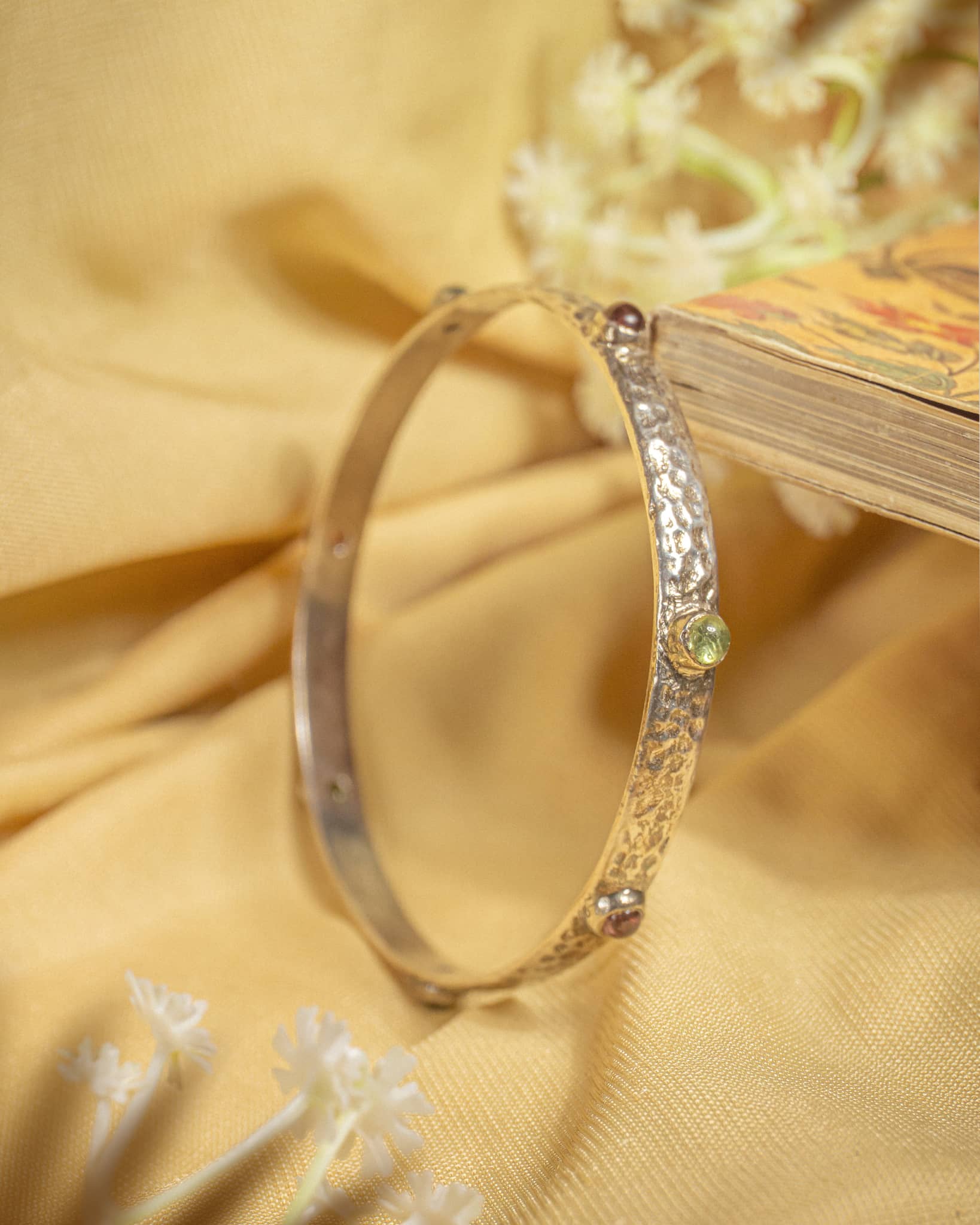 92.5 sterling silver slim hammered bangle featuring small multi-colored gemstones.
