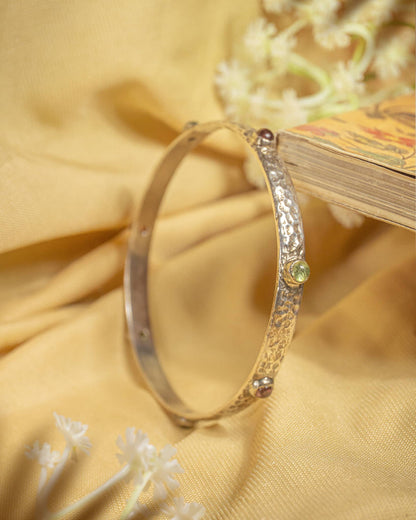92.5 sterling silver slim hammered bangle featuring small multi-colored gemstones.