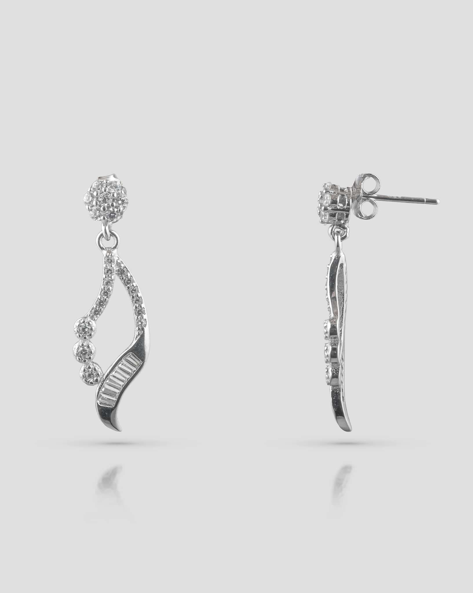 Front and side profile view of silver drop earrings showcasing a cz cluster stud, an asymmetrical open teardrop frame with round and baguette cz stones, and push-back closures.