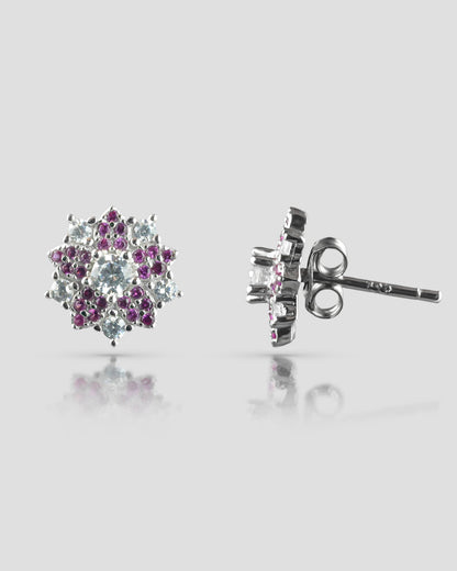 Front and side profile view of silver floral stud earrings showcasing a clear cz center, an inner ruby pink halo, and an outer clear cz petal halo with a push-back closure.