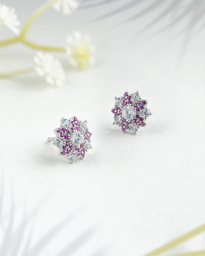 Floating angled shot of elegant 92.5 sterling silver floral stud earrings featuring a vibrant mix of pink and clear cz stones in a sunburst design.