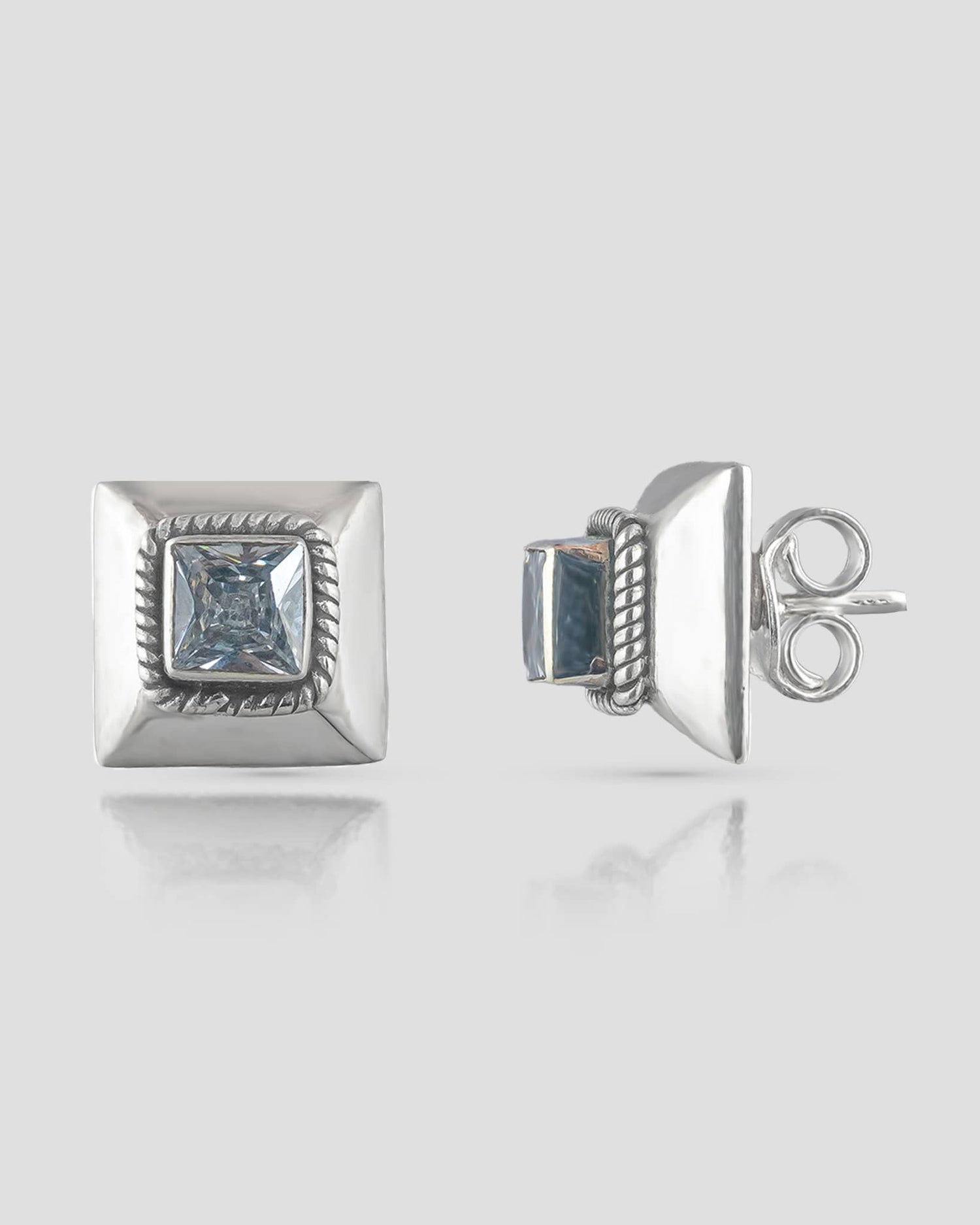 Front and side profile view of geometric silver stud earrings featuring a beveled square base, twisted rope detail, and a princess-cut clear cz stone with push-back closures.