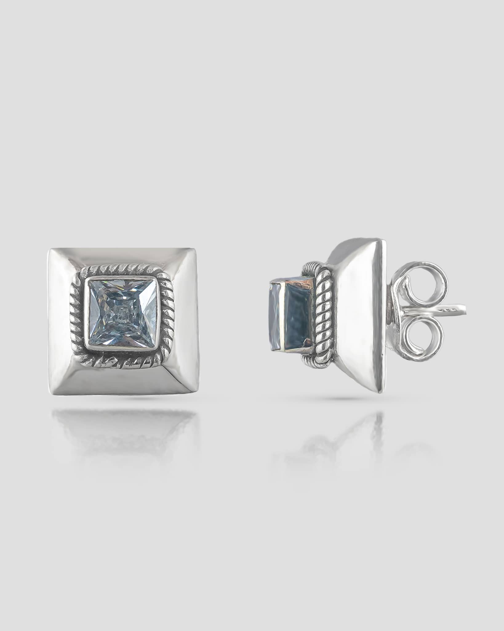 Front and side profile view of geometric silver stud earrings featuring a beveled square base, twisted rope detail, and a princess-cut clear cz stone with push-back closures.
