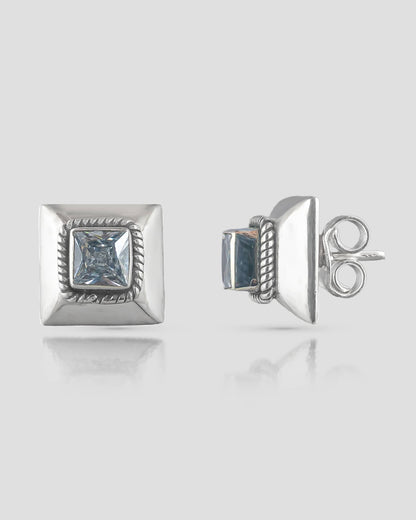 Front and side profile view of geometric silver stud earrings featuring a beveled square base, twisted rope detail, and a princess-cut clear cz stone with push-back closures.