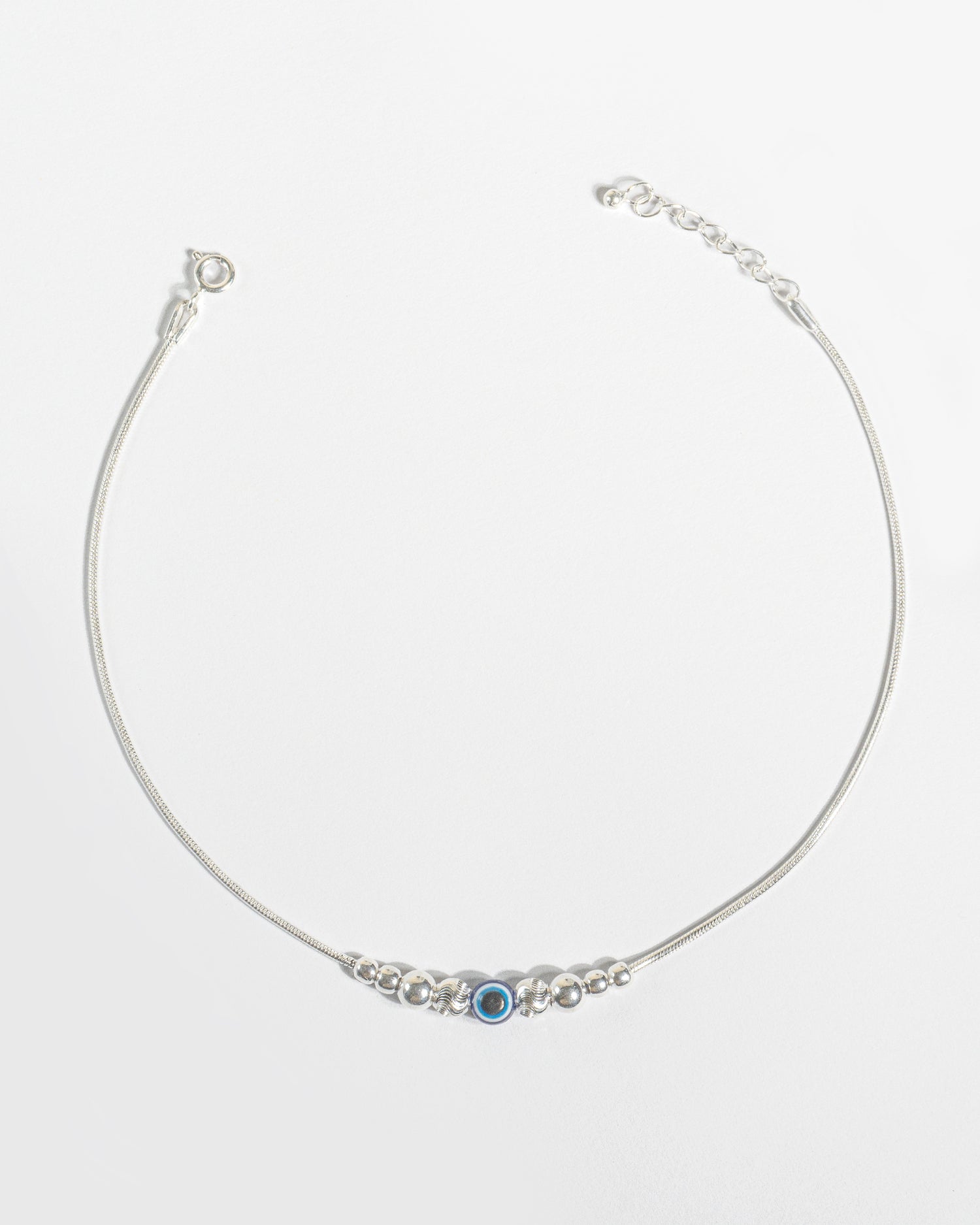 925 Sterling Silver Nazariya Payal featuring a blue evil eye bead on a snake chain, isolated on white background.
