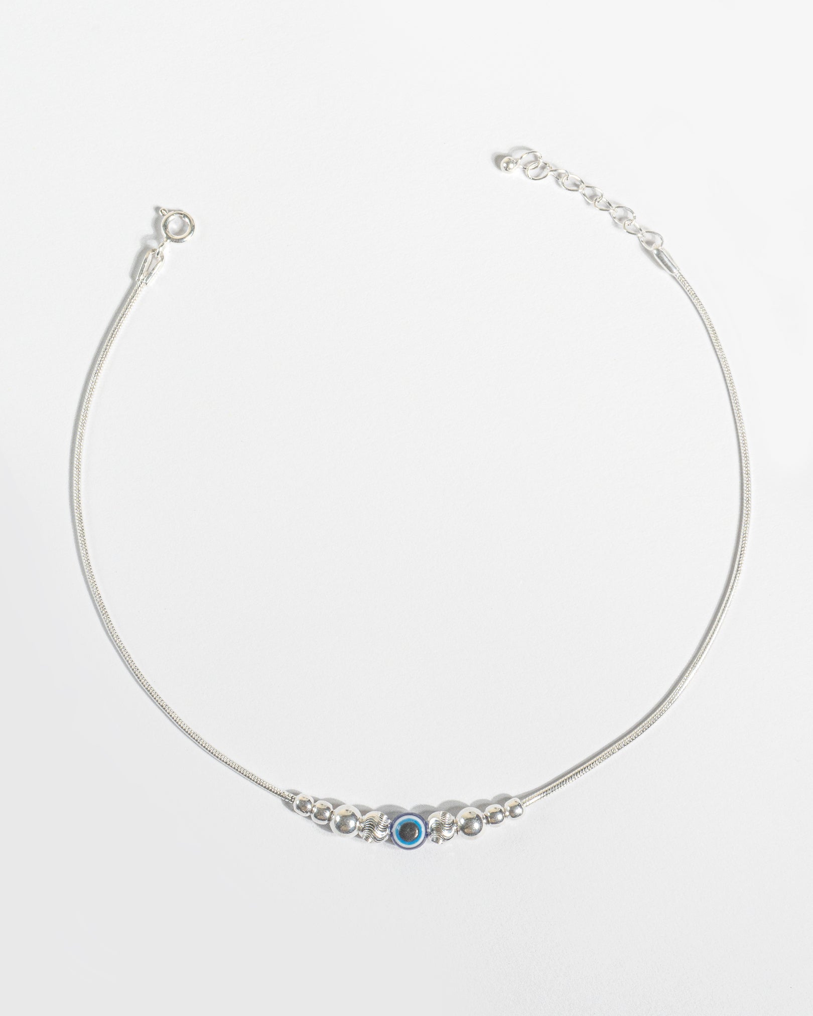 925 Sterling Silver Nazariya Payal featuring a blue evil eye bead on a snake chain, isolated on white background.