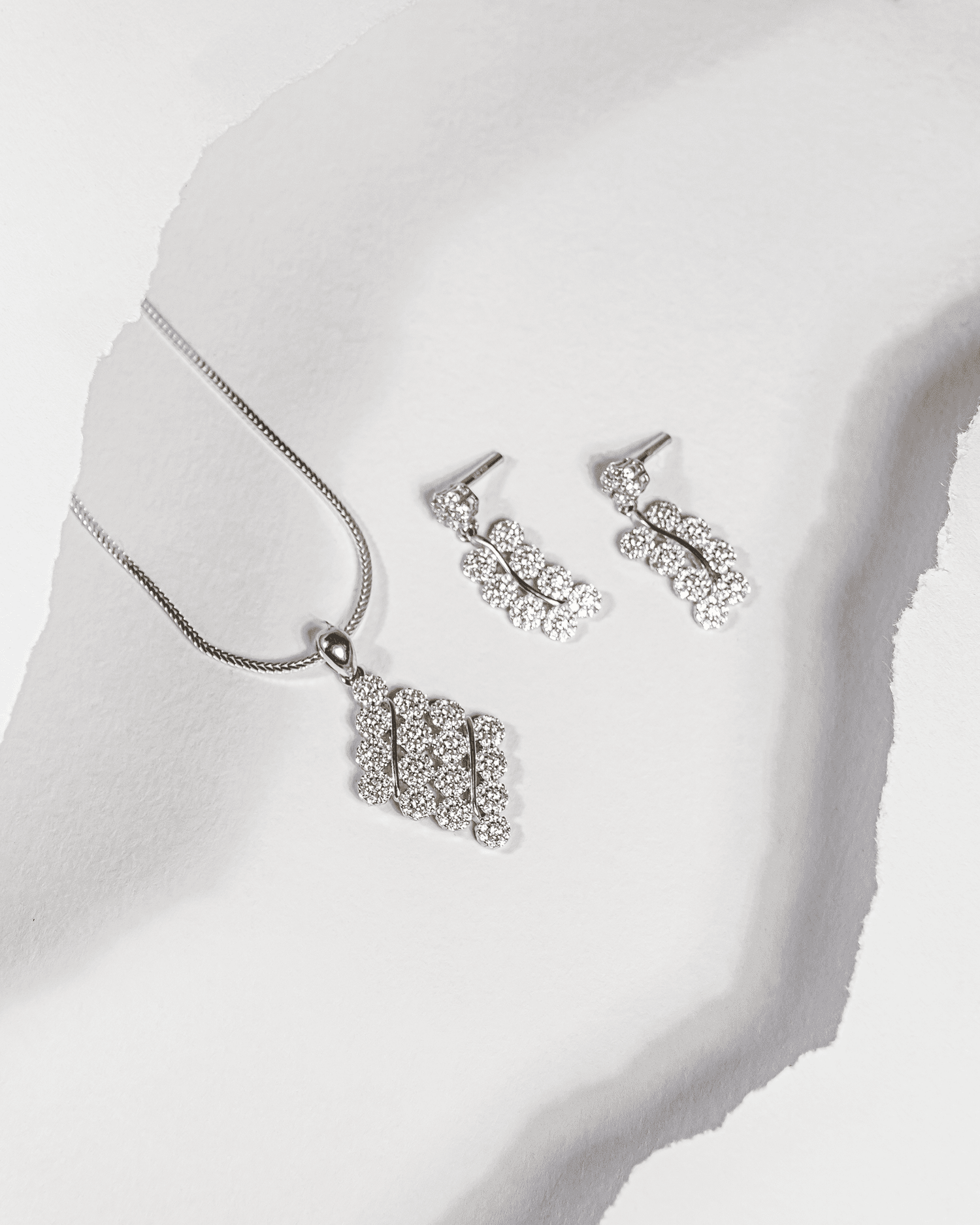 925 sterling silver diamond-shaped cluster pendant and earring set studded with cubic zirconia stones (chain not included).