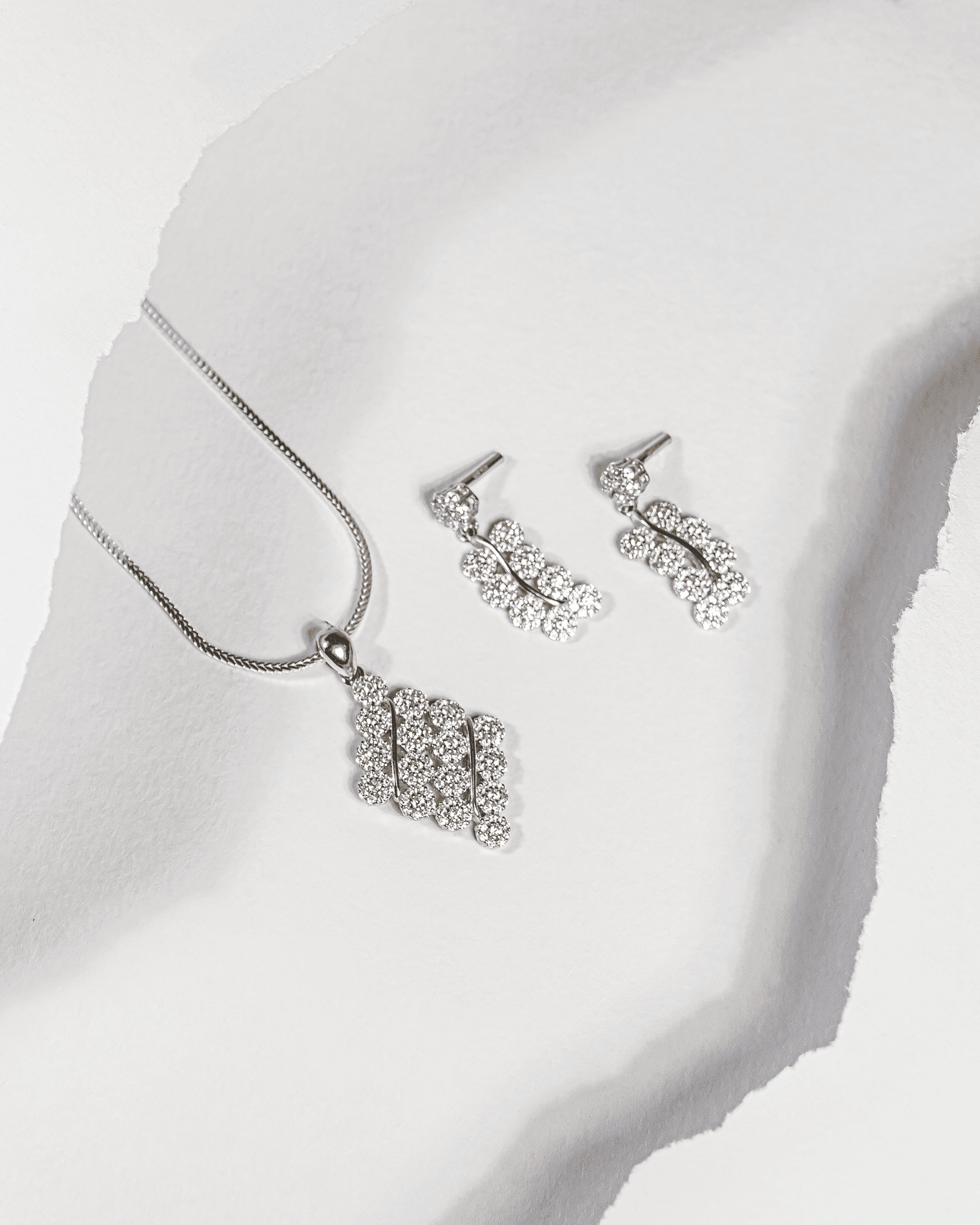 925 sterling silver diamond-shaped cluster pendant and earring set studded with cubic zirconia stones (chain not included).