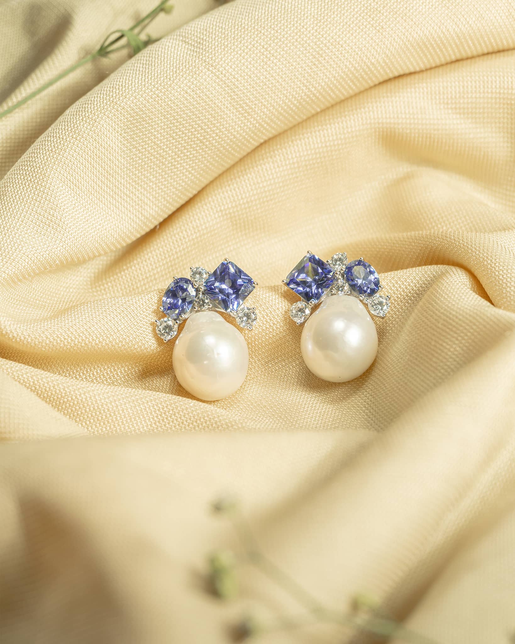 925 sterling silver drop earrings featuring an irregular baroque pearl hanging from a geometric blue stone stud.