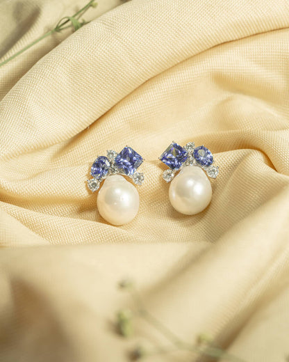 925 sterling silver drop earrings featuring an irregular baroque pearl hanging from a geometric blue stone stud.