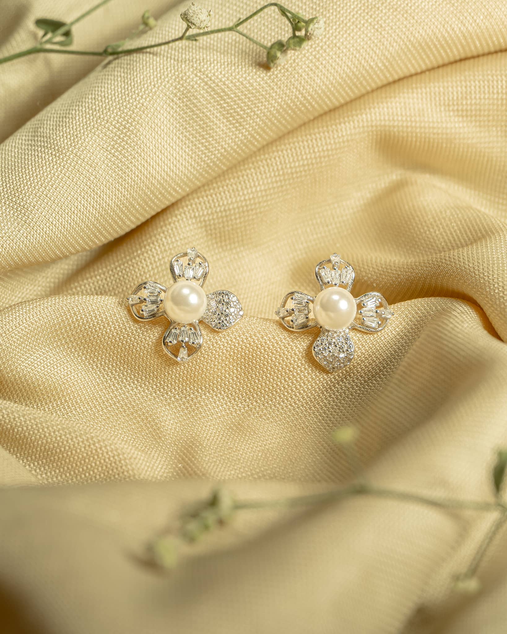 925 sterling silver geometric floral stud earrings featuring a white pearl and mixed baguette and round american diamonds.