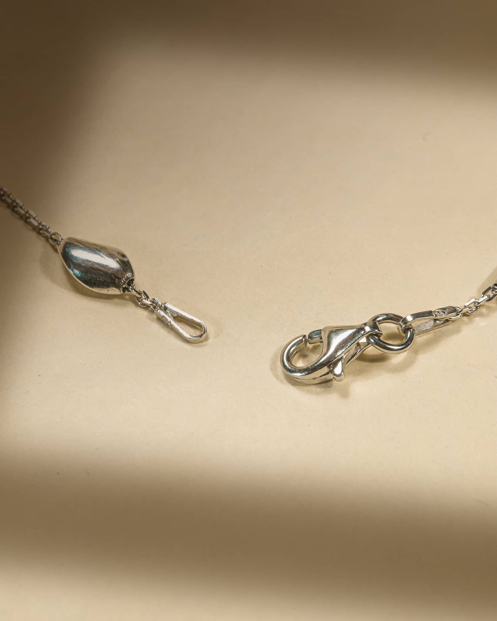 925 sterling silver minimalist anklet with spaced polished oval beads and lobster clasp.