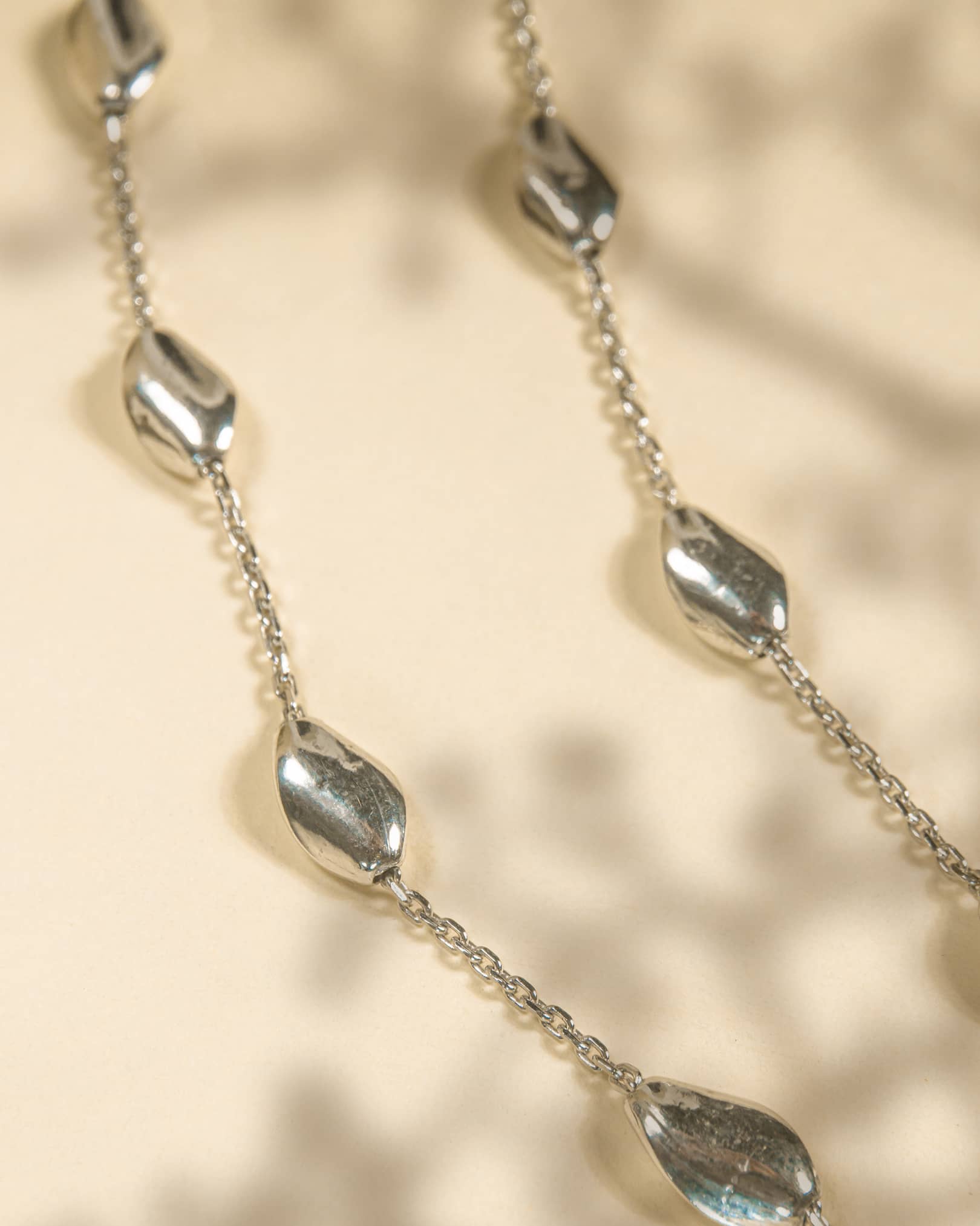 925 sterling silver minimalist anklet with spaced polished oval beads and lobster clasp.