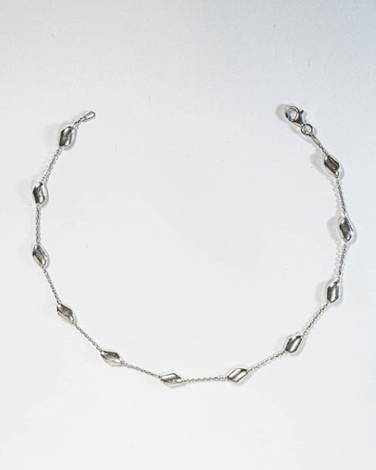 925 sterling silver minimalist anklet with spaced polished oval beads and lobster clasp.