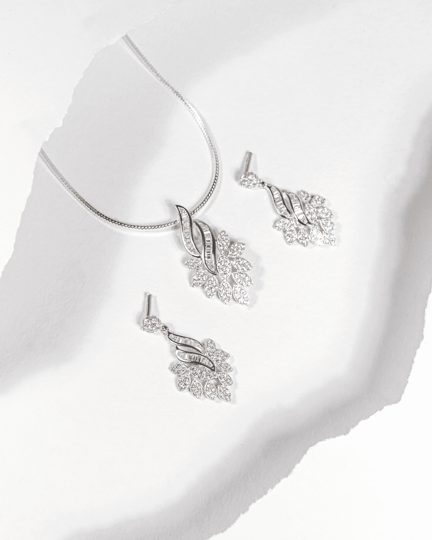 925 sterling silver pendant and earring set featuring a cascading leaf design with baguette and round CZ stones (chain not included).