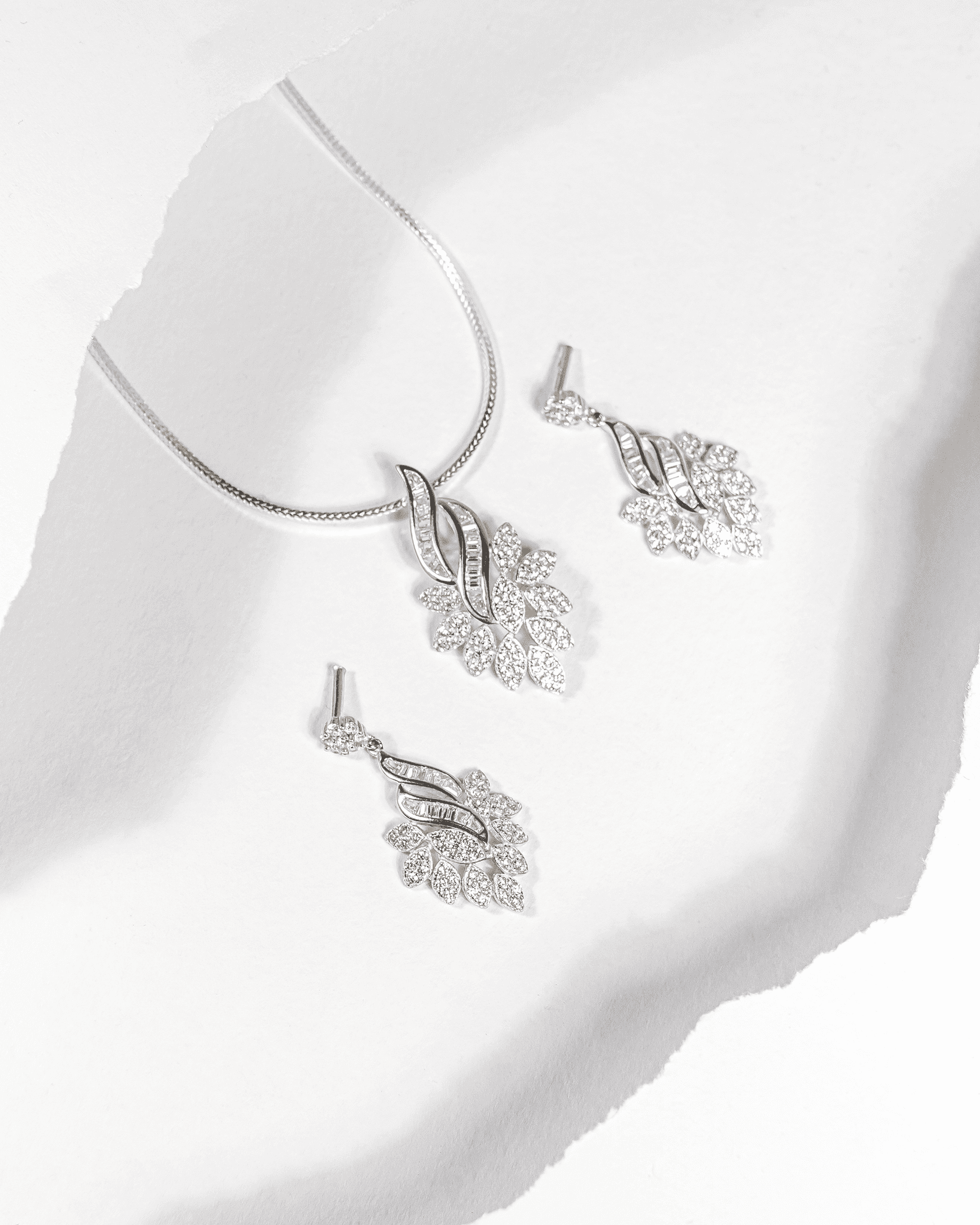 925 sterling silver pendant and earring set featuring a cascading leaf design with baguette and round CZ stones (chain not included).