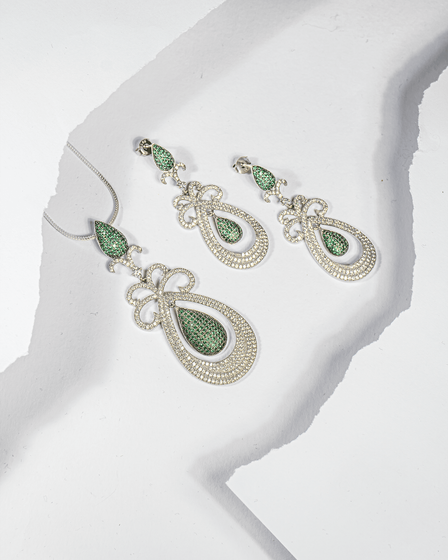925 sterling silver pendant and earring set featuring emerald green teardrop stones surrounded by white CZ (chain not included).