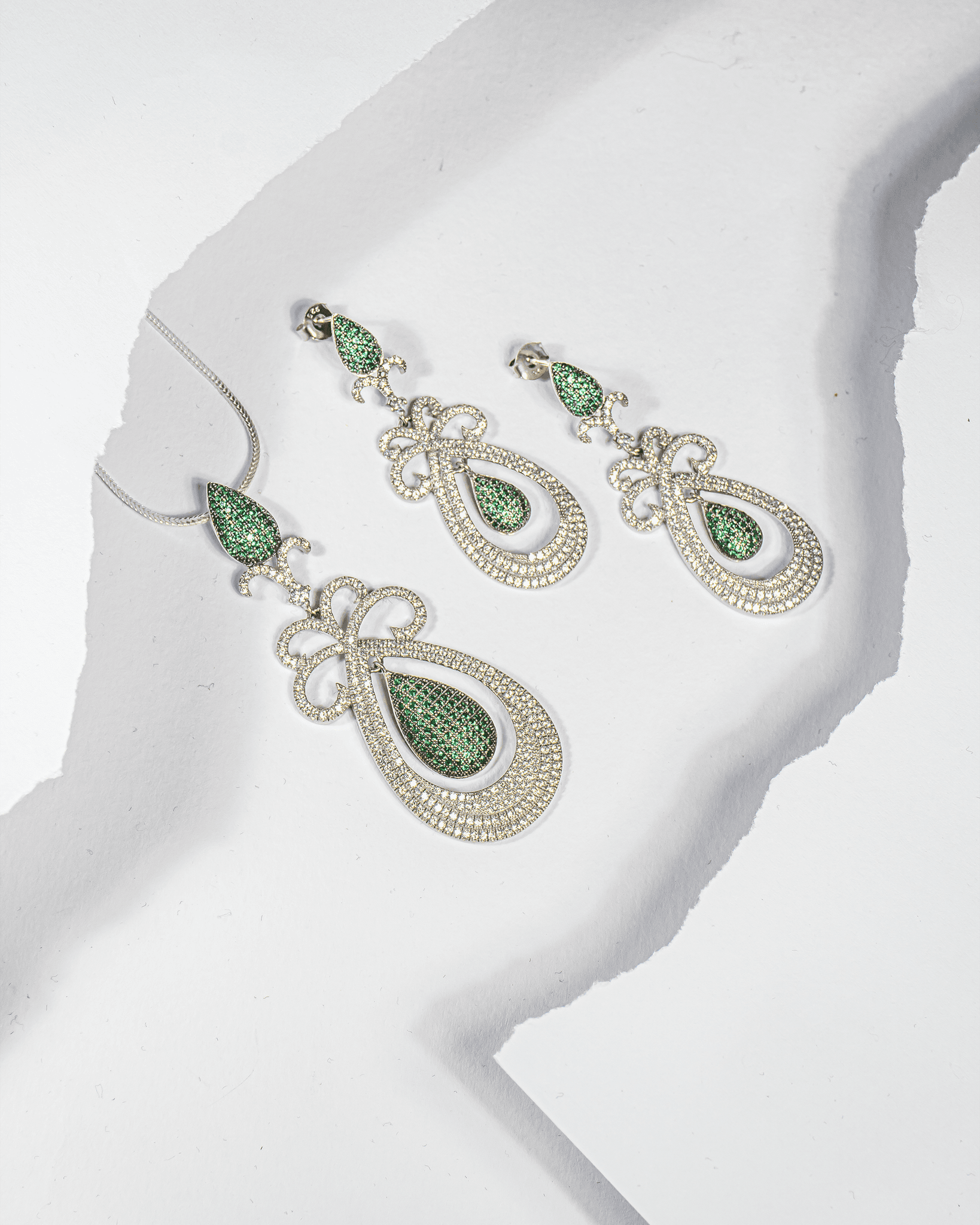 925 sterling silver pendant and earring set featuring emerald green teardrop stones surrounded by white CZ (chain not included).