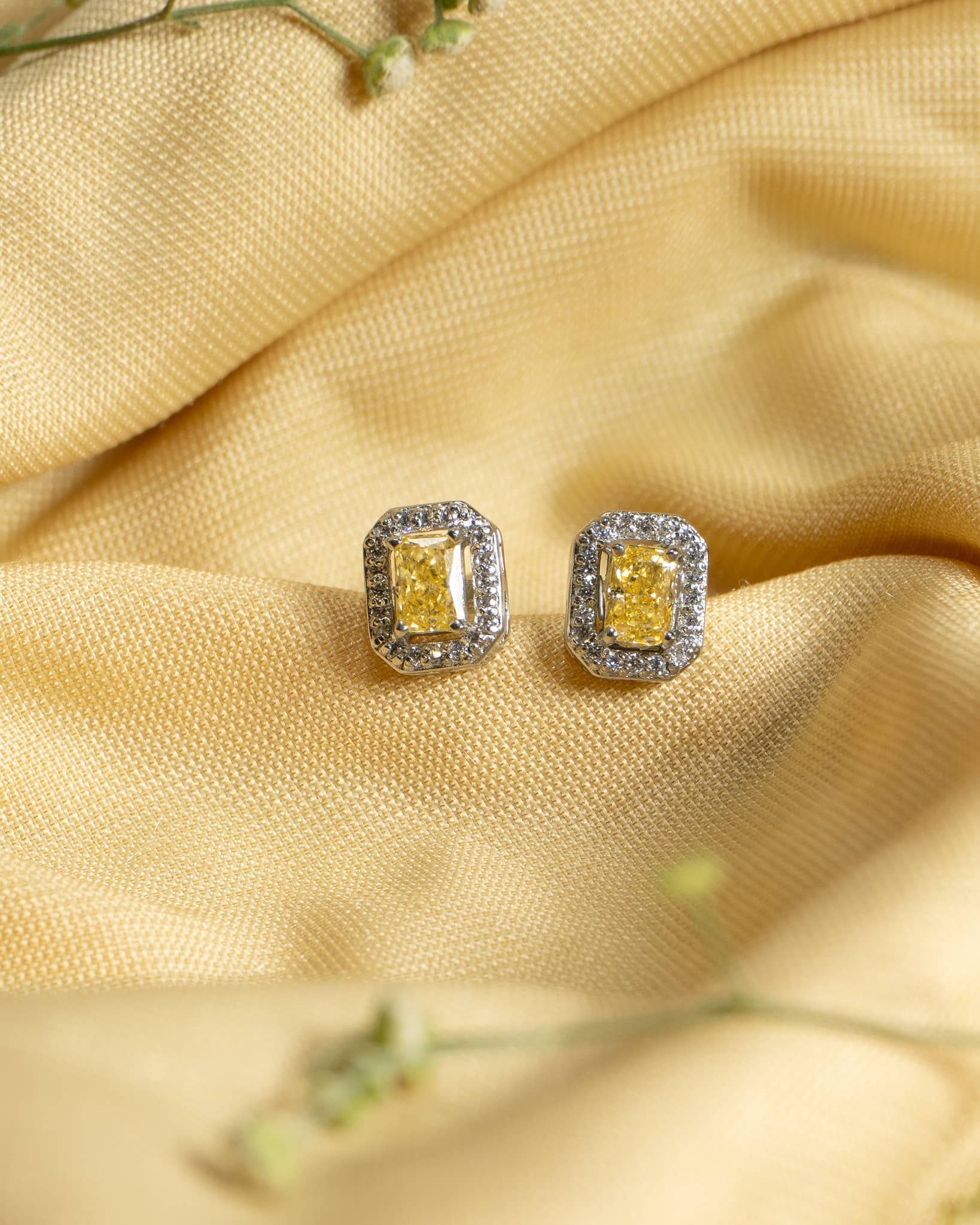 925 sterling silver stud earrings featuring a radiant cut canary yellow stone surrounded by a white diamond halo.