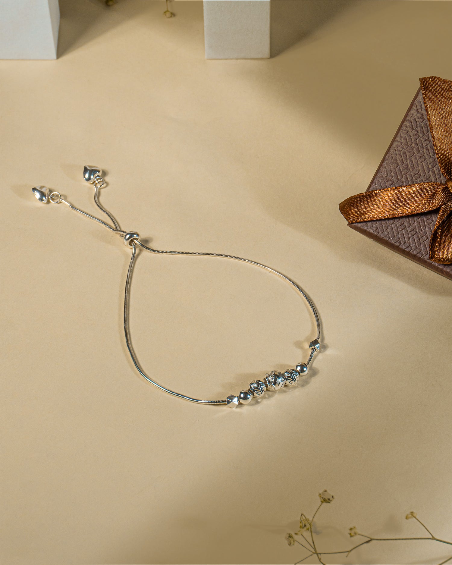 Adjustable 925 sterling silver slider anklet (payal) with textured beads and hanging heart charms.