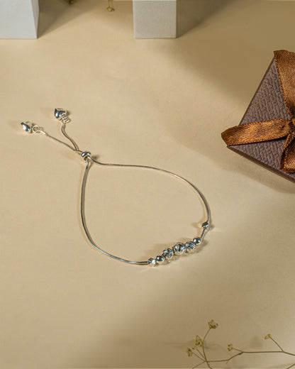 Adjustable 925 sterling silver slider anklet (payal) with textured beads and hanging heart charms.
