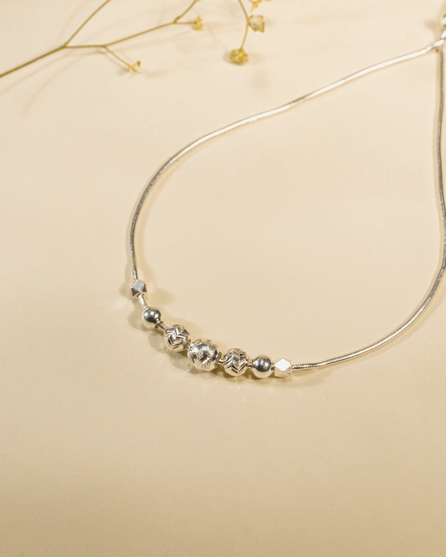 Adjustable 925 sterling silver slider anklet (payal) with textured beads and hanging heart charms.