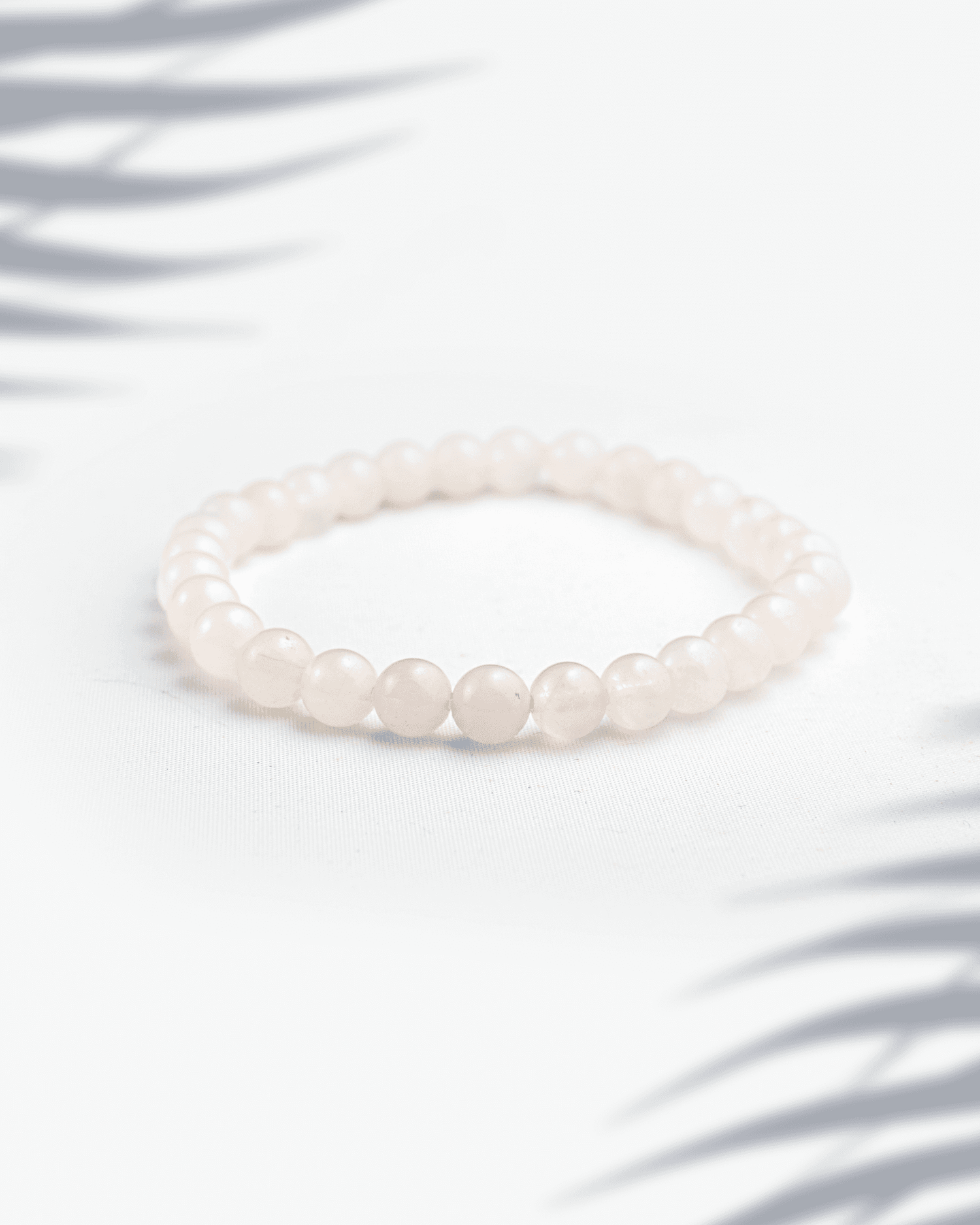 Dainty 6mm natural rose quartz and moonstone bracelet featuring small pink and white beads.