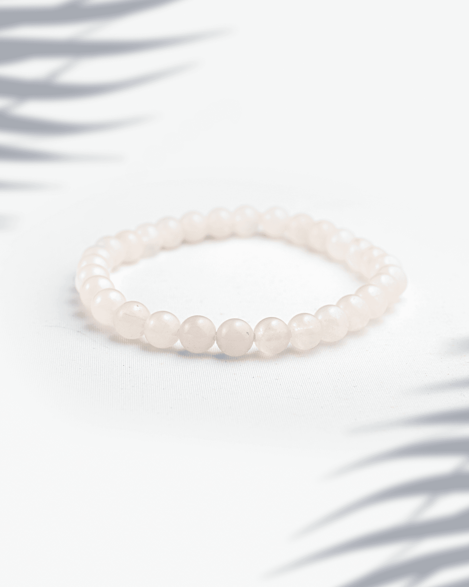 Dainty 6mm natural rose quartz and moonstone bracelet featuring small pink and white beads.