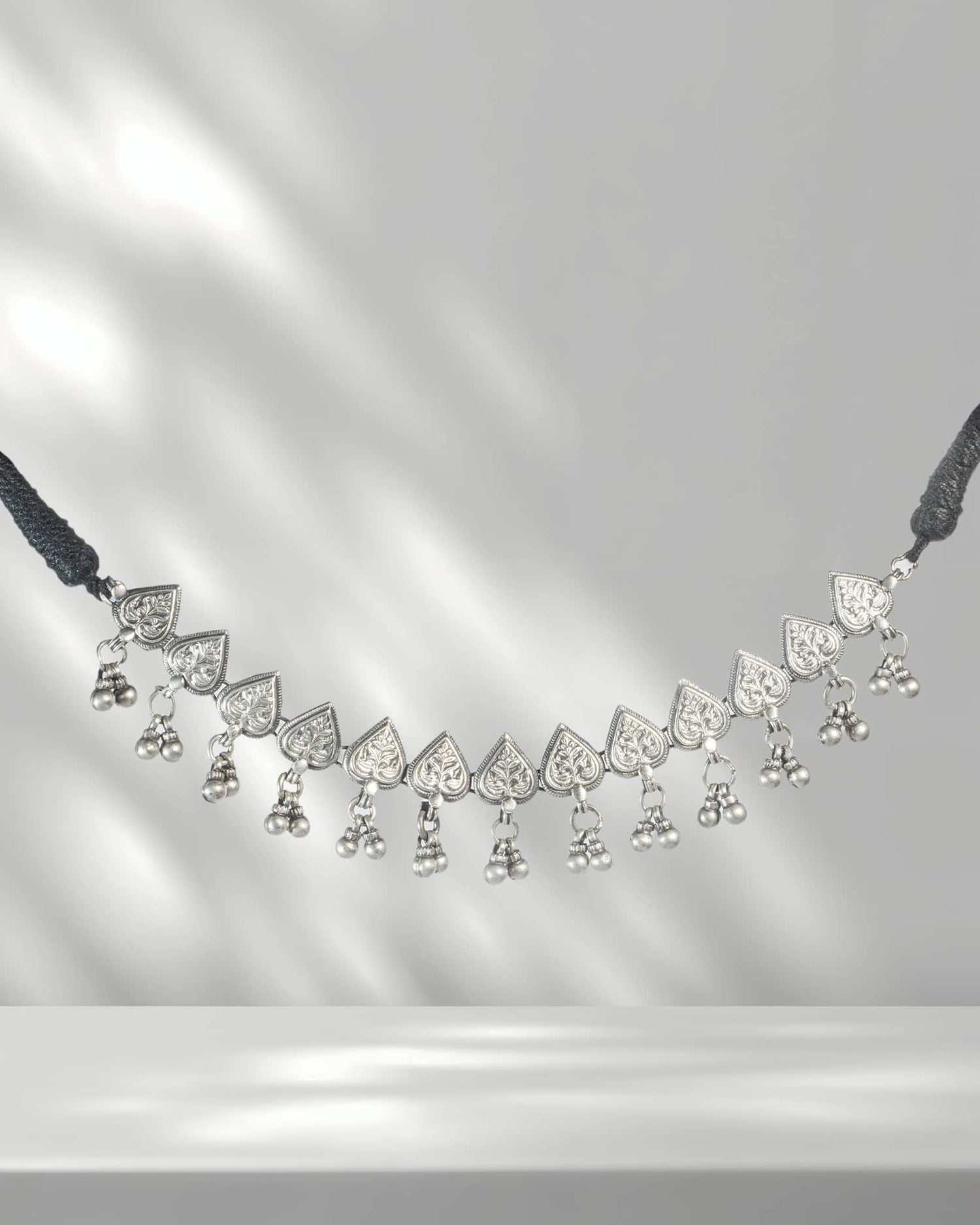 Delicate necklace with heart-shaped pendants on a gray background