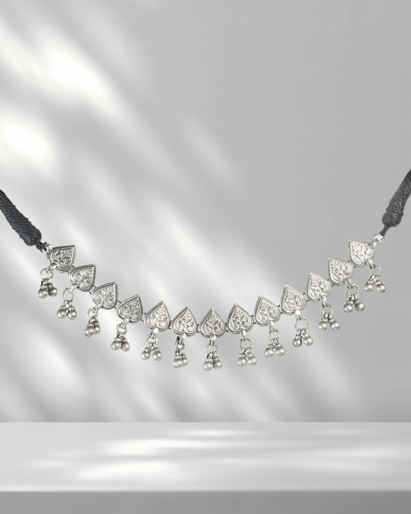 Delicate necklace with heart-shaped pendants on a gray background